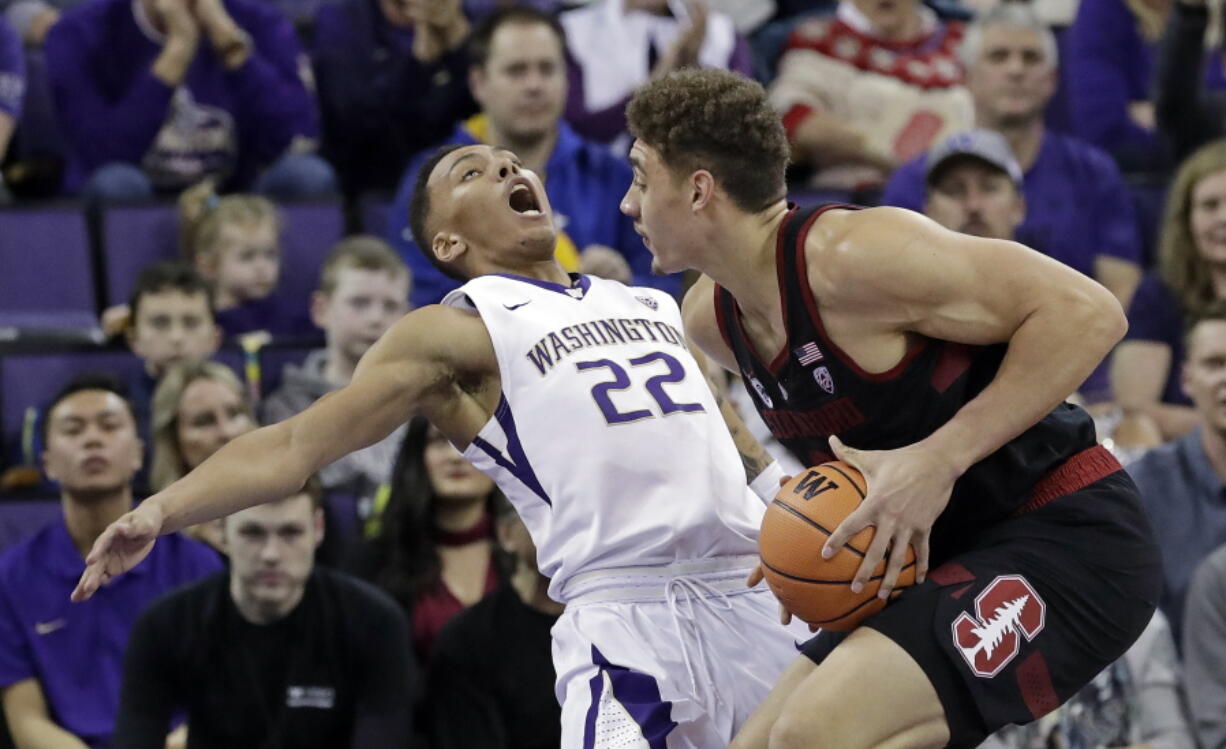 Washington’s Dominic Green (22) tumbles backward after colliding with Stanford’s Reid Travis in the first half of an NCAA college basketball game Saturday, Jan. 13, 2018, in Seattle.