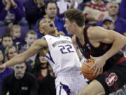 Washington’s Dominic Green (22) tumbles backward after colliding with Stanford’s Reid Travis in the first half of an NCAA college basketball game Saturday, Jan. 13, 2018, in Seattle.