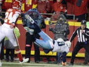 Tennessee Titans quarterback Marcus Mariota (8) leaps over the goal line for a touchdown in front of Kansas City Chiefs defensive back Will Redmond (24) during the second half of an NFL wild-card playoff football game in Kansas City, Mo., Saturday, Jan. 6, 2018.