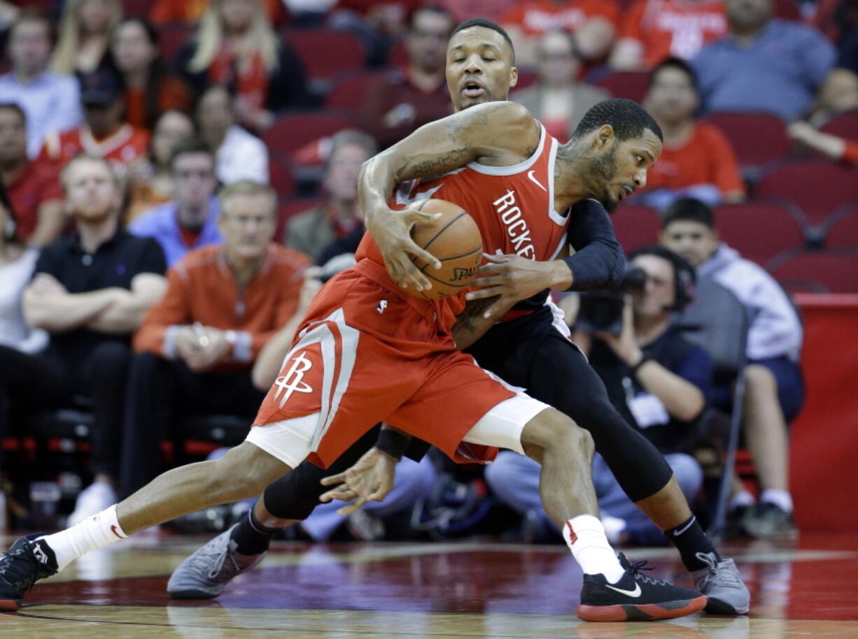 Houston Rockets forward Trevor Ariza (1) tries to drive around Portland Trail Blazers guard Damian Lillard (0) during the second half of an NBA basketball game Wednesday, Jan. 10, 2018, in Houston.