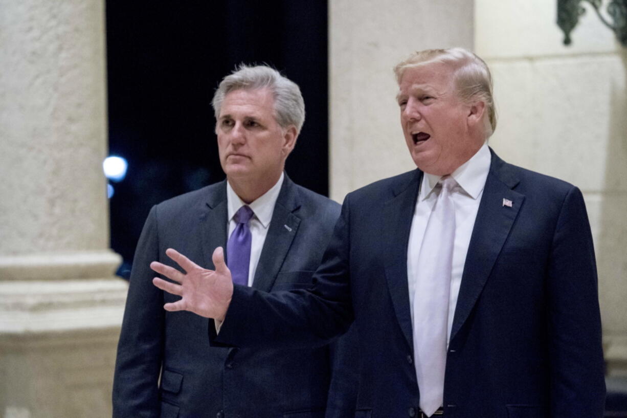 President Donald Trump, right, accompanied by House Majority Leader Kevin McCarthy, R-Calif., speaks to members of the media as they arrive for a dinner at Trump International Golf Club in West Palm Beach, Fla., Sunday, Jan. 14, 2018.