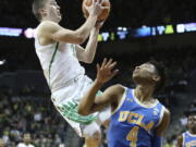 Oregon’s Payton Pritchard, left, shoot over UCLA’s Jaylen Hands during the first half of an NCAA college basketball game Saturday, Jan. 20, 2018, in Eugene, Ore.