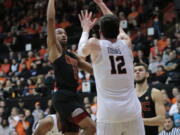 Southern California’s Jordan McLaughlin (11) shoots over Oregon State’s Drew Eubanks (12) in the first half of an NCAA college basketball game in Corvallis, Ore., Saturday, Jan. 20, 2018. (AP Photo/Timothy J.