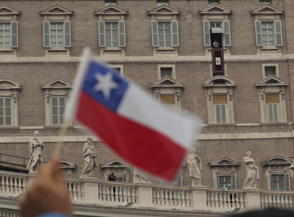 A man waves a Chilean flag as Pope Francis recites the Angelus prayer in St. Peter’s Square at the Vatican on Sunday. Pope Francis says while fear of migrants is “legitimate’ it’s a sin if that causes hostility. Francis invited migrants, refugees, asylum-seekers, newly arrived immigrants and second-generation immigrant families to a special Mass he celebrated Sunday in St. Peter’s Basilica.