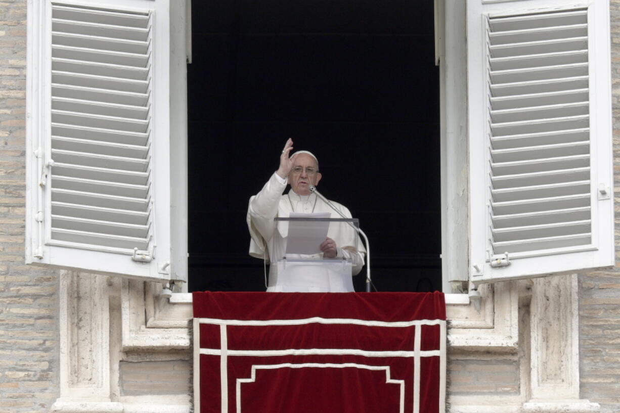 Pope Francis recites the Angelus noon prayer from the window of his studio overlooking St. Peter’s Square at the Vatican on Sunday.