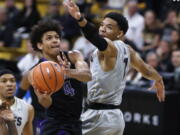 Washington guard Matisse Thybulle, left, drive to the basket past Colorado guard Tyler Bey during the first half of an NCAA college basketball game Saturday, Jan. 20, 2018.