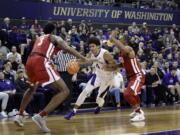 Washington guard Matisse Thybulle (4) drives between Washington State forward Robert Franks, left, and guard Milan Acquaah, right, Sunday, Jan. 28, 2018, in the first half of an NCAA college basketball game in Seattle. (AP Photo/Ted S.