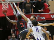 Utah forward Donnie Tillman (3) goes to the basket as Washington forward Sam Timmins (33) defends in the first half during an NCAA college basketball game Thursday, Jan. 18, 2018, in Salt Lake City.