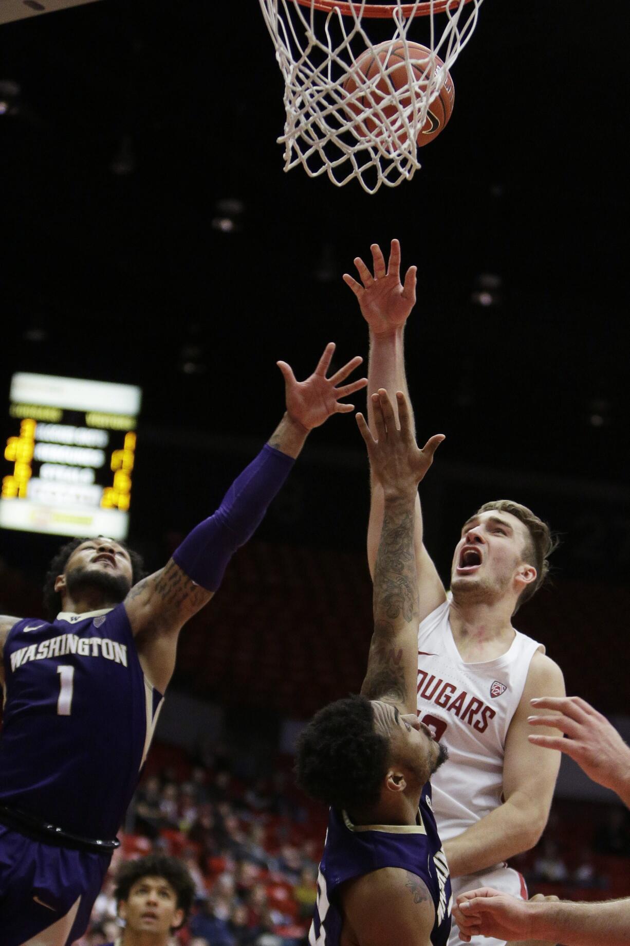 Washington State forward Jeff Pollard, right, shoots against Washington guards David Crisp (1) and Carlos Johnson during the second half of an NCAA college basketball game in Pullman, Wash., Saturday, Jan. 6, 2018.