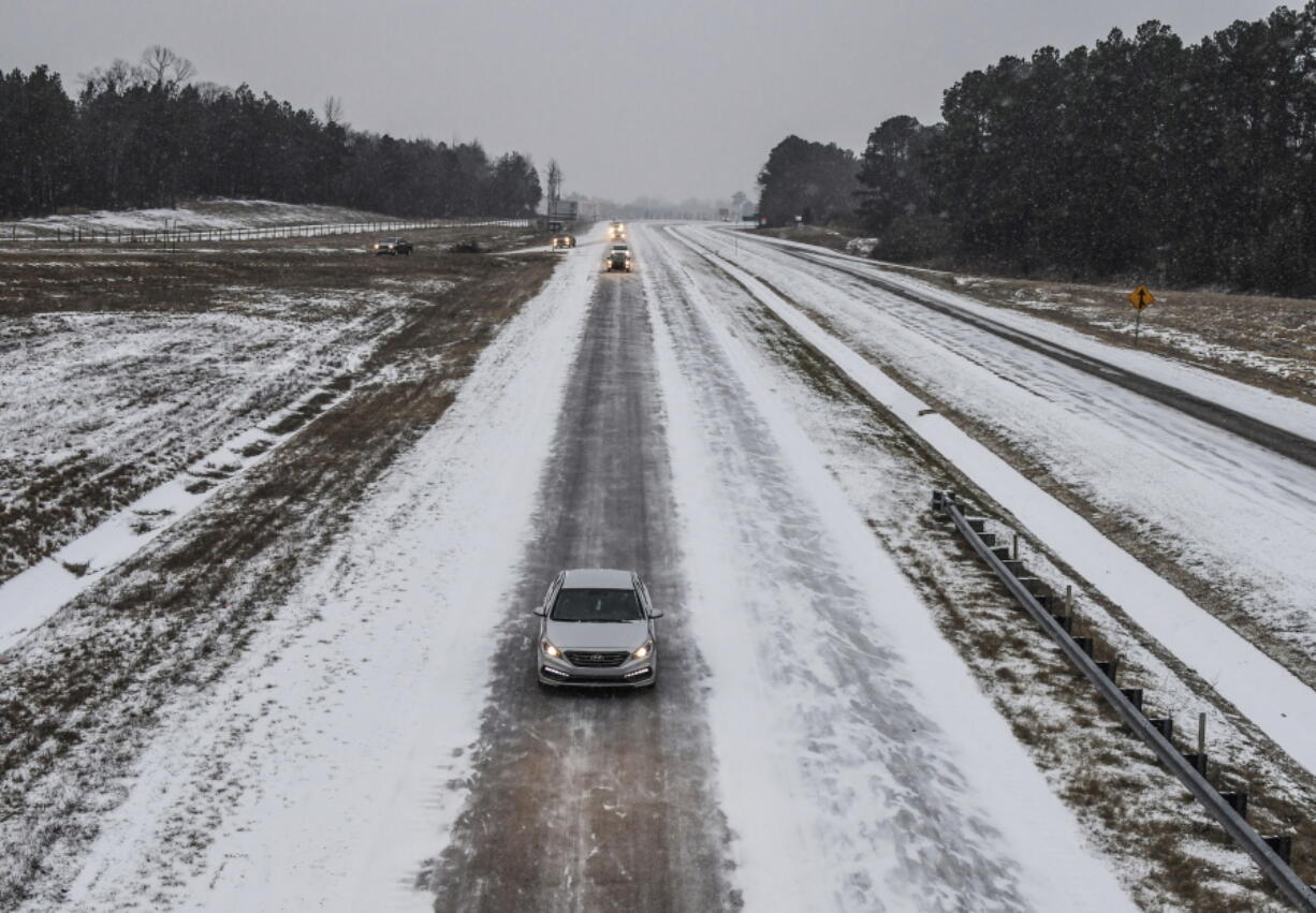 Traffic makes its way north on Highway 7 as snow falls in Oxford, Miss., on Tuesday. The National Weather Service on Tuesday issued winter storm warnings in parts of Louisiana and Mississippi.