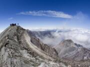 Members of the media stand at the 8,363-foot summit of Mount St. Helens in 2006 after officials announced the resumption of climbing on the volcano. The online system created for climbing permit sales crashed Thursday, frustrating thousands of hopeful climbers.