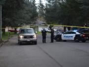 Officers direct a resident past a roadblock set up for a shooting investigation March 19 on Northeast 140th Avenue, where two men were found dead.