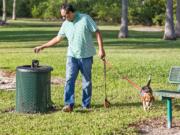 Emmanuel Cabrera Muoz properly disposes of his dog’s waste in a plastic bag and throws it in a trash can Feb. 7 at Kennedy Dog Park in Coconut Grove. C.M.