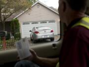 For enforcement, the Vancouver Police Department relies on volunteers to inventory out-of-state license plates parked in Vancouver neighborhoods. Scott Abels, reads an Oregon license plate to another volunteer taking notes while surveying the Landover-Sharmel neighborhood.