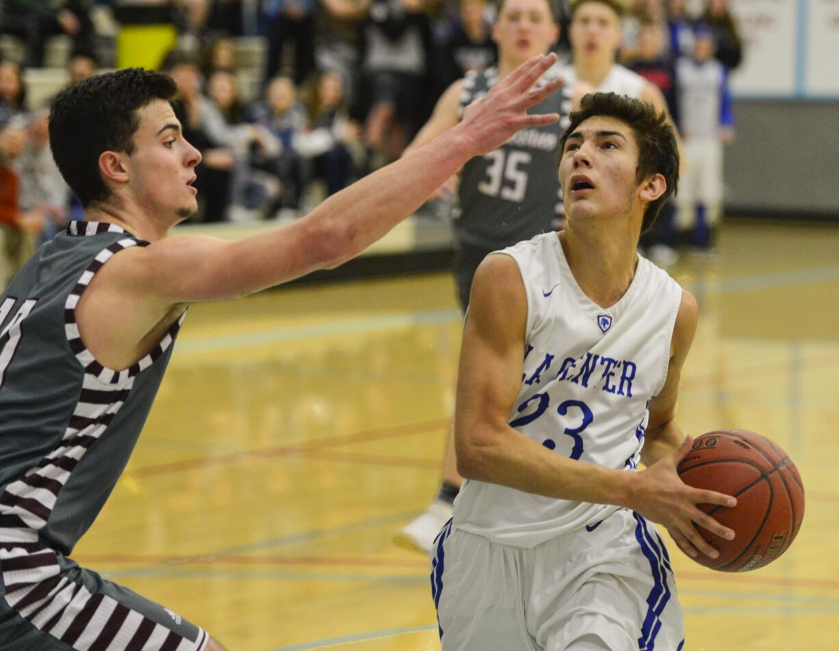 La Center's Hunter Ecklund steps past Montesano's Trevor Ridgway in the first quarter of the 1A State Regional game at Mark Morris High School.