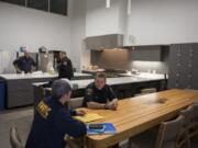 Vancouver Fire Department Capt. Scott Blanton, center, talks with his son Alex Blanton of Battle Ground, left, in the kitchen area at the new Vancouver Fire Station 2. Both stations feature massive kitchens with 24-foot ceilings to accommodate the large crews.