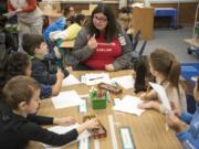 Fort Vancouver High School senior Alexandra Mayo helps kindergartners with a drawing and reading project Tuesday morning at Peter S. Ogden Elementary School. Mayo is in the high school’s Careers in Education program, learning the skills required to become a teacher.