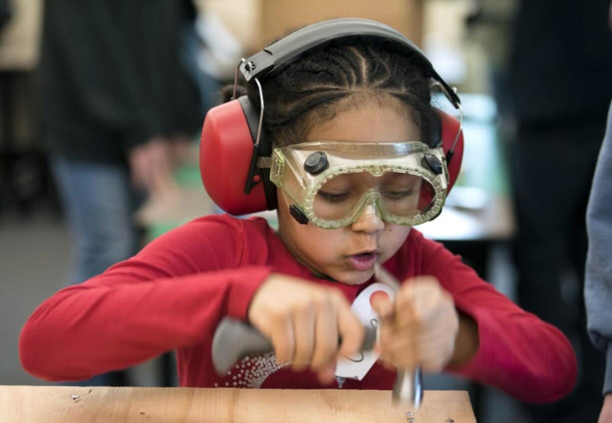 Orchards Elementary School first-grader Uma Solomon hammers together a chicken brooder during class at the elementary school in Vancouver on Tuesday afternoon. The first-graders split into groups and worked with Heritage High School students to build brooders — incubated homes for newly hatched chickens — together.