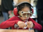 Orchards Elementary School first-grader Uma Solomon hammers together a chicken brooder during class at the elementary school in Vancouver on Tuesday afternoon. The first-graders split into groups and worked with Heritage High School students to build brooders — incubated homes for newly hatched chickens — together.