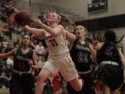 Haley Hanson, left, of Camas drives to the basket as Anna Browne, 23, of Hazen defends in the 4A girls basketball bi-district tournament at Camas high school.