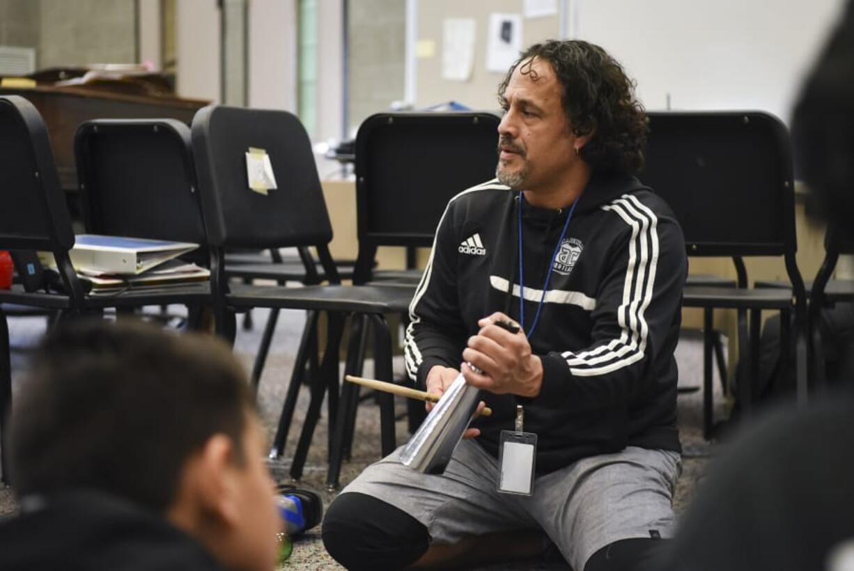 Edward Esparza, the leader of “One of a Kind Drumline,” an afterschool music program at Fort Vancouver High School, demonstrates the cowbell to elementary through high school students before drumeline rehearsal in the choir room at Fort Vancouver High School.