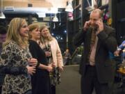 Elizabeth Schalk, from left, administrative assistant to Evergreen Superintendent John Steach, Steach’s wife, Heather, and Sue Steinbrenner, director of facilities for Evergreen Public Schools, wait to hear the results of the district’s $695 million bond measure from John Steach, on phone, while at Hopworks Urban Brewery in Vancouver on Tuesday. Steach was on the phone with Clark County Auditor Greg Kimsey, learning that 60.12 percent of voters supported the construction bond, which would replace schools, build a new school and make districtwide improvements.