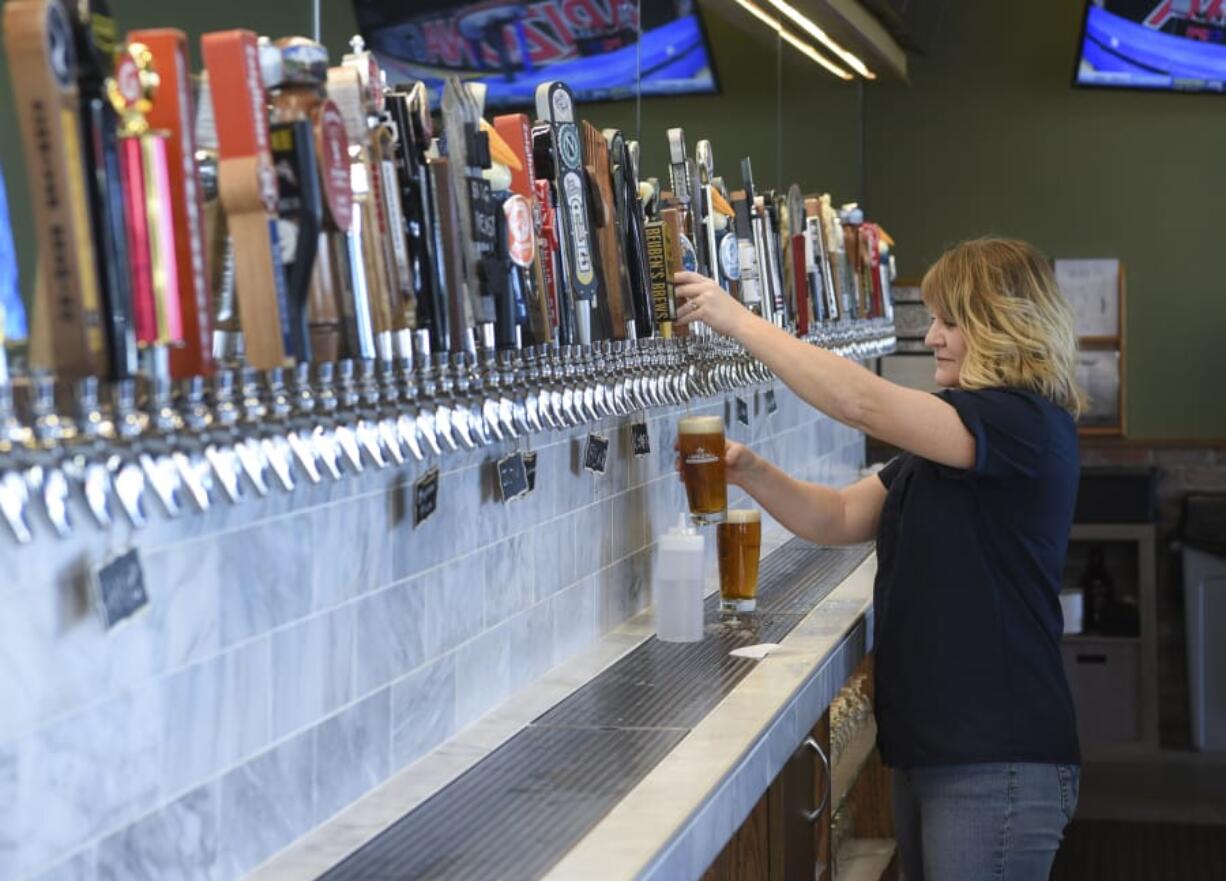 Becca Blair pours a beer for a customer at Growlers USA.