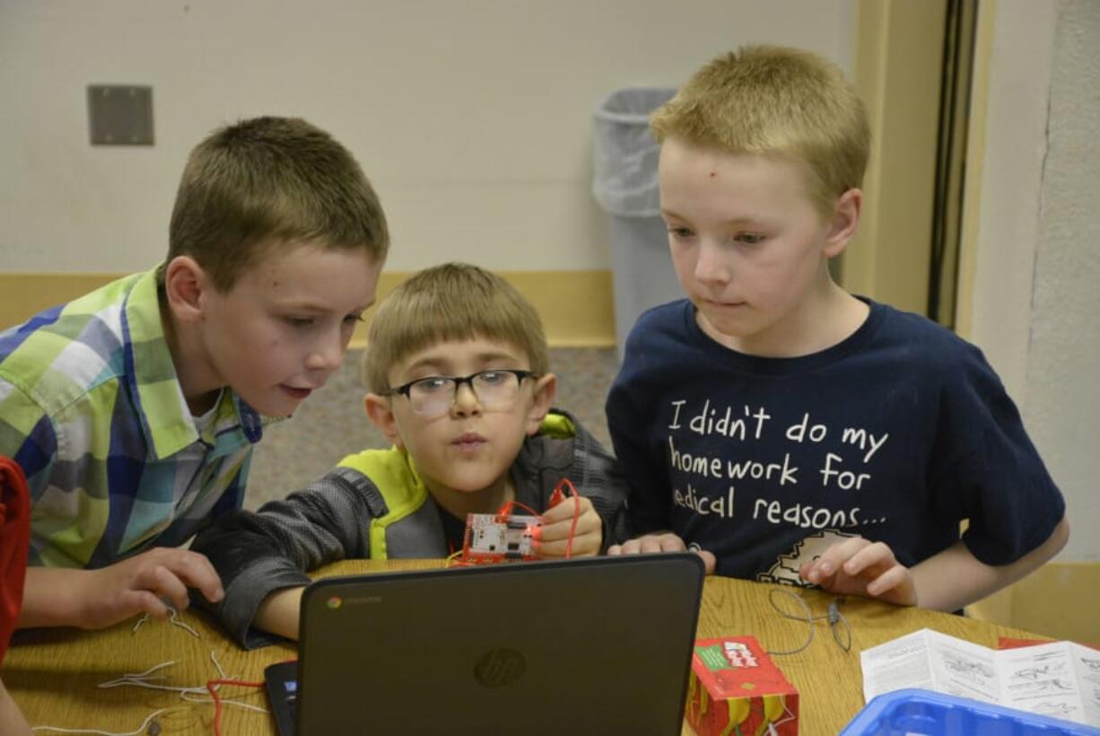 Washougal: Hathaway Elementary School students, from left, Cole Wilson, Carter Boucher and Leo Perry at a workshop put on by the Washougal School District and Washougal Community Library to give students hands-on experience learning about circuits, electricity and conductors.