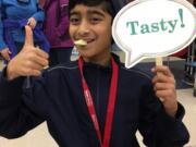 Orchards: Orchards Elementary School fourth-grader Suhayb Quddus tries pears as part of Washington State University Extension’s Supplemental Nutrition Assistance Program Education’s Harvest of the Month program.