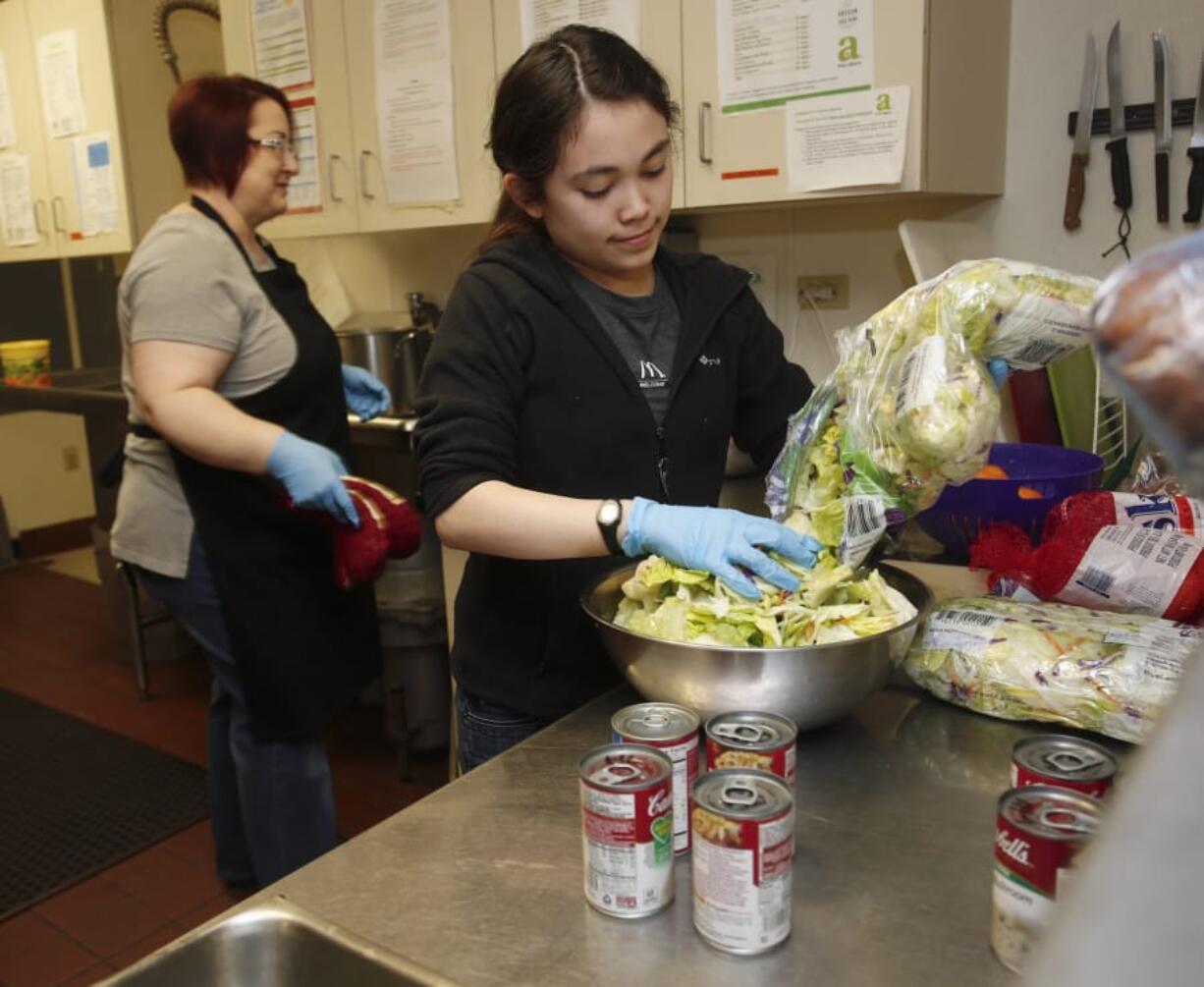 Volunteer Nicole Nugent prepares dinner for patrons at the Share Orchards. A small army of volunteers, backed with community donations of ingredients, helps provide dinner for patrons at Share’s shelters each night.