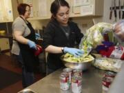 Volunteer Nicole Nugent prepares dinner for patrons at the Share Orchards. A small army of volunteers, backed with community donations of ingredients, helps provide dinner for patrons at Share’s shelters each night.