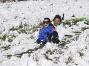 Aiko Nies, 10, left, steers a sled while her friend, Mya Ellertson, 9, holds on tight at Mount Vista near Washington State University Vancouver on Monday morning. Mya, who with Aiko attends King’s Way Christian School, said she was excited to have a day off of school — though she’d have had it anyway. Monday was Presidents Day.