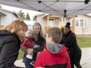 Vancouver Mayor Anne McEnerny-Ogle speaks with Taylor Hauxhurst, 12, about his new home, while his mother, Tiffany Hauxhurst, and brother Grayson, 2, look on. Dakota Palmore, who also got the keys to her Habitat for Humanity home on Sunday, is greeting a well-wisher after the ceremony commemorating the two families’ new homes.