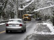 Many local schools operated with a late start on Thursday morning, but because temperatures lingered just above freezing the freeways and metro-area streets were mostly bare. Drivers are seen along Blandford Drive canyon from MacArthur Boulevard to Evergreen Boulevard late Thursday morning, Feb. 22, 2018, in Vancouver.