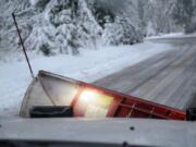 With the road cleared, Nick Eiesland, lets the snowplow blade hang from the front of truck. Working overnight Wednesday, snowplow crews cleared primary and secondary roads across Clark County.