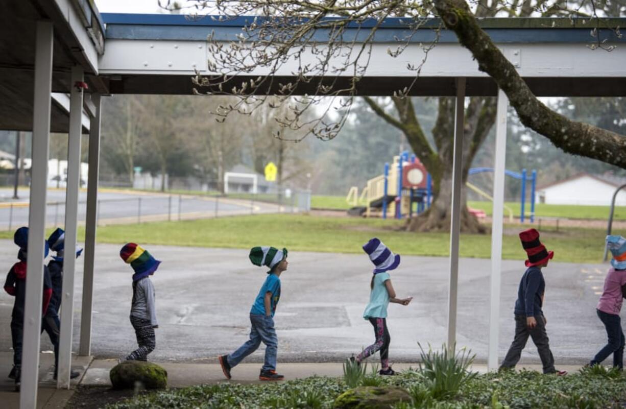 First-graders walk back to their classrooms after enjoying a meal of green eggs and ham at Marrion Elementary School on Tuesday morning in Vancouver. The school kicked off Read Across America week with a colorful breakfast, donated by Beaches Restaurant & Bar, in honor of Dr. Seuss’ beloved children’s books. Beaches owner Mark Matthias and a team of volunteers have been feeding green eggs and ham to students for 23 years.