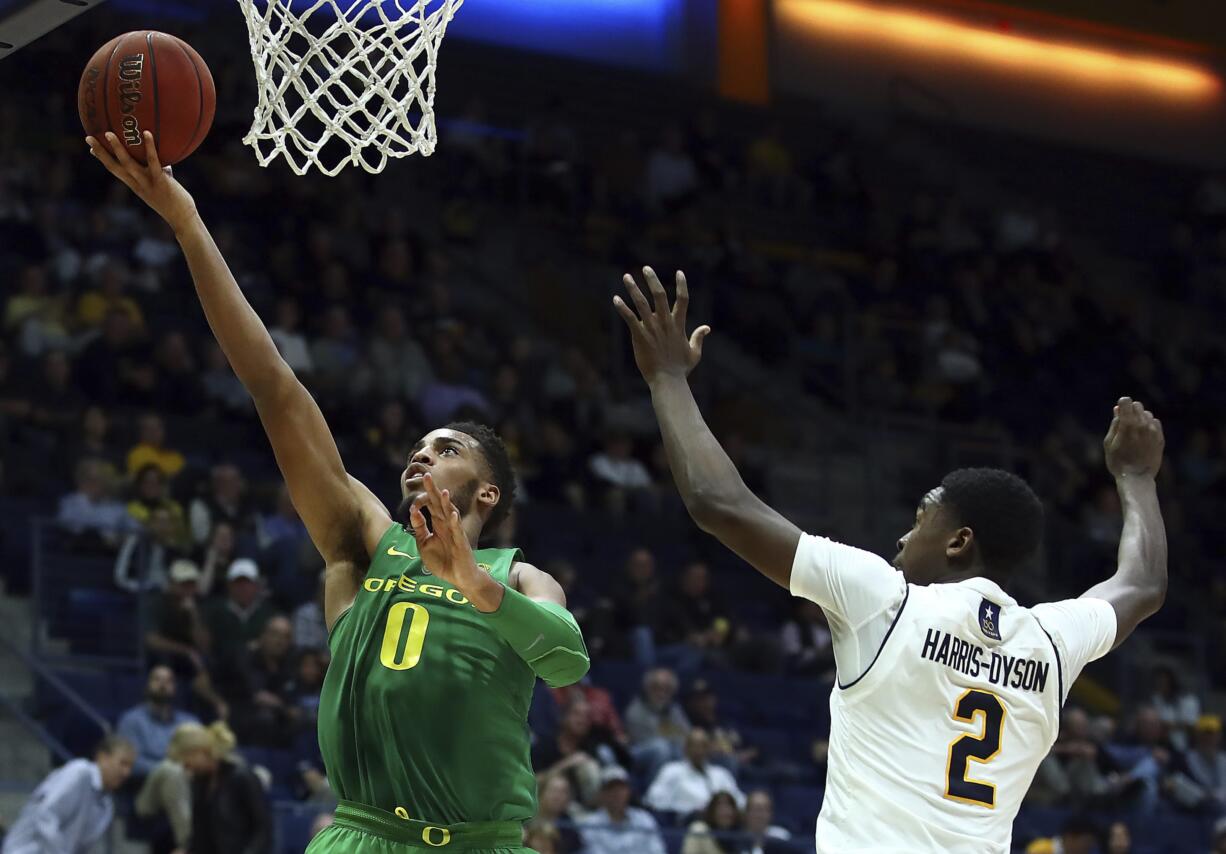 Oregon's Troy Brown, left, lays up a shot in front of California's Juhwan Harris-Dyson (2) in the second half of an NCAA college basketball game Thursday, Feb. 1, 2018, in Berkeley, Calif.