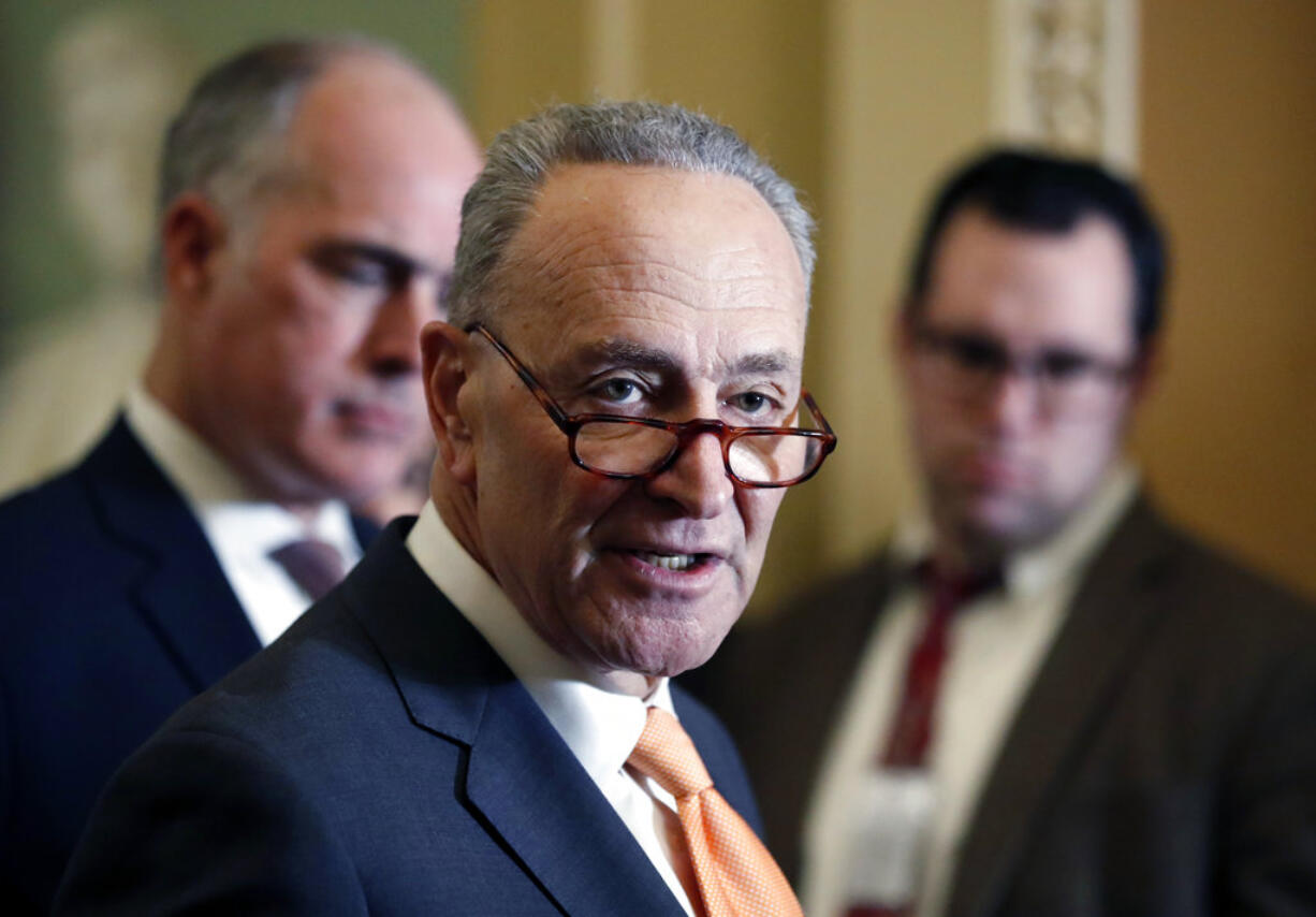 Senate Minority Leader Chuck Schumer of N.Y., center, accompanied by Sen. Bob Casey, D-Pa., at left, speaks on Capitol Hill, Tuesday, Feb. 6, 2018 in Washington.