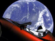 This image from video provided by SpaceX shows the company's spacesuit in Elon Musk's red Tesla sports car which was launched into space during the first test flight of the Falcon Heavy rocket on Tuesday, Feb. 6, 2018.