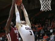 Washington State's Robert Franks, left, goes over Oregon State's Tres Tinkle, right, for a rebound in the first half of an NCAA college basketball game in Corvallis, Ore., Thursday, Feb. 8, 2018. (AP Photo/Timothy J.