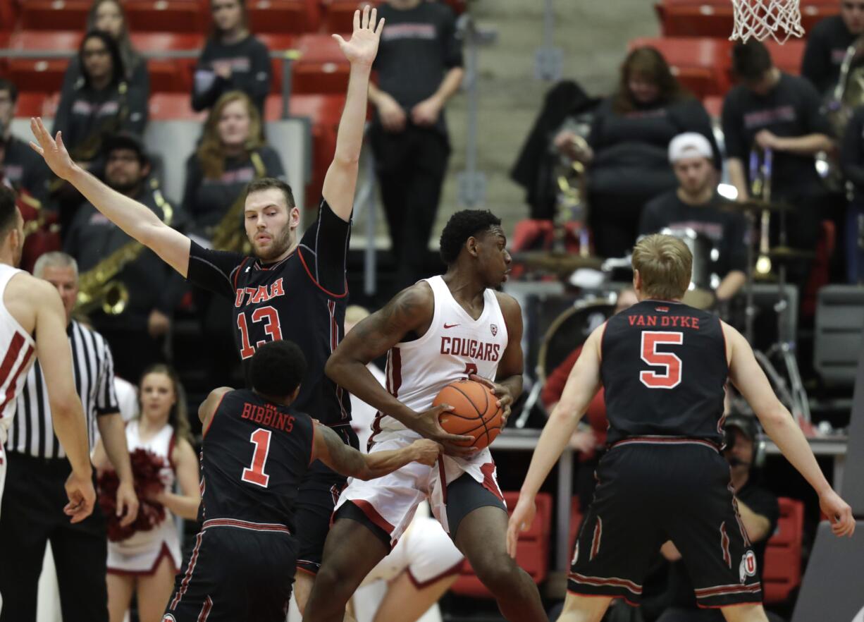 Washington State forward Robert Franks, second from left, spins through the defense of Utah's Parker Van Dyke (5), Justin Bibbins (1) and David Collette (13) as he drives to the basket during the first half of an NCAA college basketball game Saturday, Feb. 17, 2018, in Pullman, Wash. (AP Photo/Ted S.