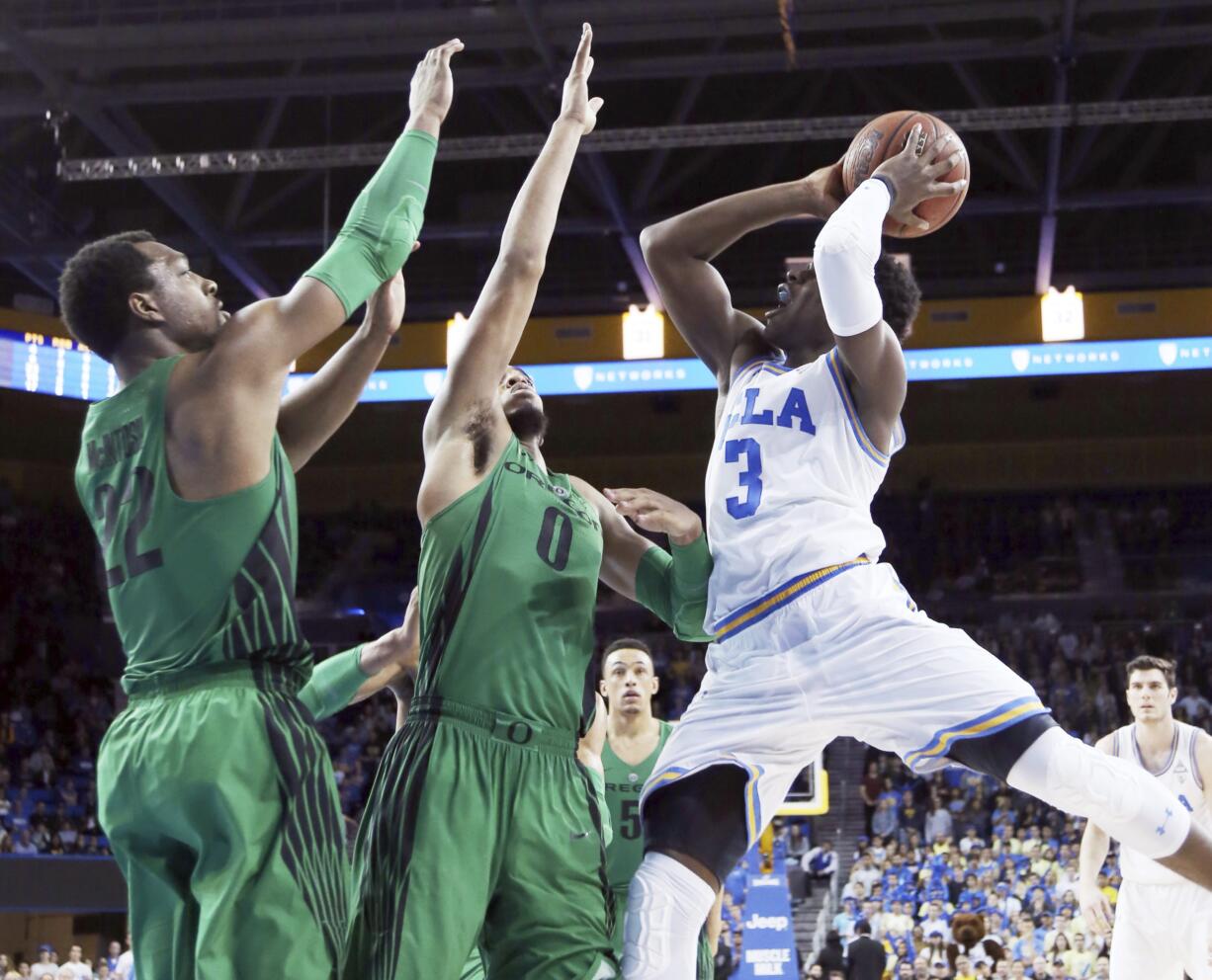 UCLA guard Aaron Holiday (3) shoots as Oregon forwards Mikyle McIntosh (22) and Troy Brown (0) defend during overtime in an NCAA college basketball game in Los Angeles Saturday, Feb. 17, 2018. UCLA won 86-78.