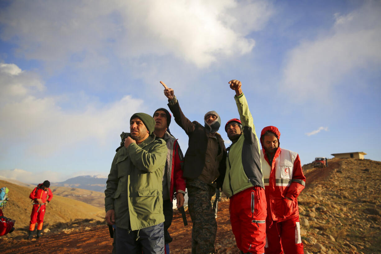 In this photo provided by Tasnim News Agency, rescue and search team members search for wreckage of a plane that crashed on Sunday in the Dena mountains in southern Iran, Monday, Feb. 19, 2018. Iranian search and rescue teams on Monday reached the site of a plane crash the previous day that authorities say killed all 65 people on board, Iran's Press TV reported.