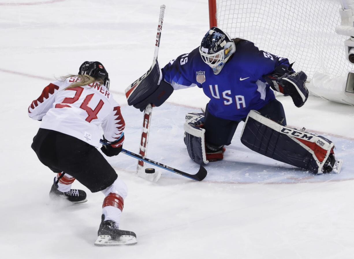 Goalie Maddie Rooney (35), of the United States, blocks a shot by Natalie Spooner (24), of Canada, in the penalty shootout during the women's gold medal hockey game at the 2018 Winter Olympics in Gangneung, South Korea, Thursday, Feb. 22, 2018.