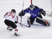 Goalie Maddie Rooney (35), of the United States, blocks a shot by Natalie Spooner (24), of Canada, in the penalty shootout during the women's gold medal hockey game at the 2018 Winter Olympics in Gangneung, South Korea, Thursday, Feb. 22, 2018.