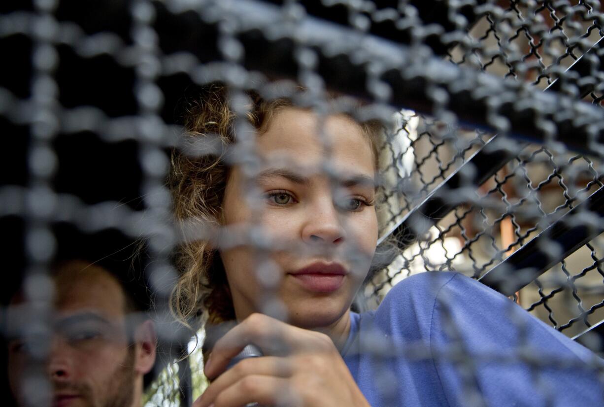 Anastasia Vashukevich sits in a police transport vehicle outside a detention center in Pattaya, south of Bangkok, Thailand, Wednesday, Feb. 28, 2018, after being arrested Sunday in the Thai resort city of Pattaya. Vashukevich told The Associated Press from a police van Wednesday that she fears for her life, and wants to exchange information on alleged Russian ties to U.S. President Donald Trump’s campaign for her own personal safety.