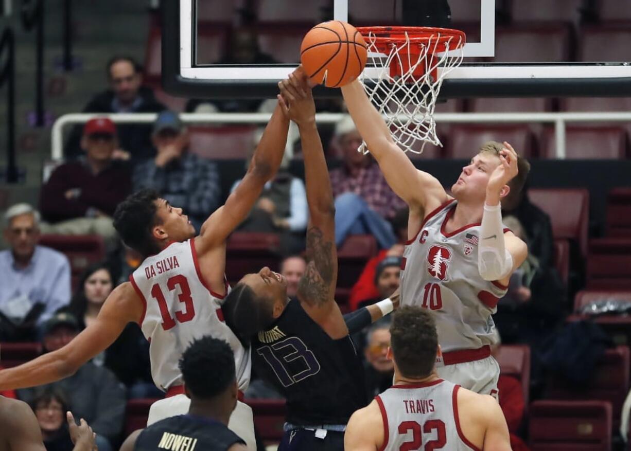 Stanford forward Michael Humphrey (10) and teammate Oscar da Silva (13) block Washington forward Hameir Wright (13) during the first half of an NCAA college basketball game Thursday, Feb. 22, 2018, in Stanford, Calif.