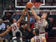 Stanford forward Michael Humphrey (10) and teammate Oscar da Silva (13) block Washington forward Hameir Wright (13) during the first half of an NCAA college basketball game Thursday, Feb. 22, 2018, in Stanford, Calif.