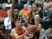 Oregon State’s Tres Tinkle, front, drives to the basket past Arizona State’s Kimani Lawrence, rear left, and Kodi Justice, rear right, in the first half of an NCAA college basketball game in Corvallis, Ore., Saturday, Feb. 24, 2018. (AP Photo/Timothy J.