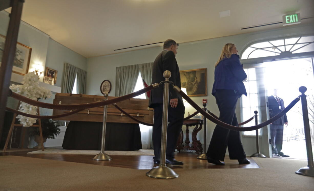 A couple walks past the casket after paying respects to Billy Graham during a public viewing at the Billy Graham Library in Charlotte, N.C., Monday.